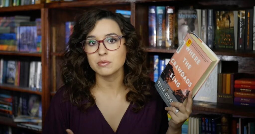 Girl holding a book "Where the Crawdads Sing"